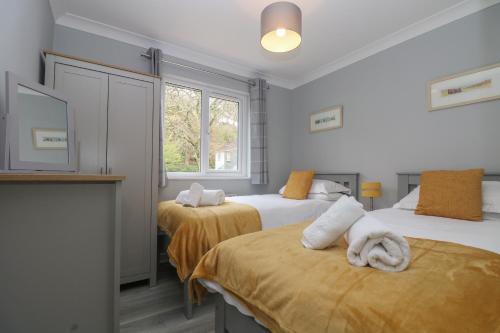 een slaapkamer met twee bedden met handdoeken erop bij Compass Point in Falmouth