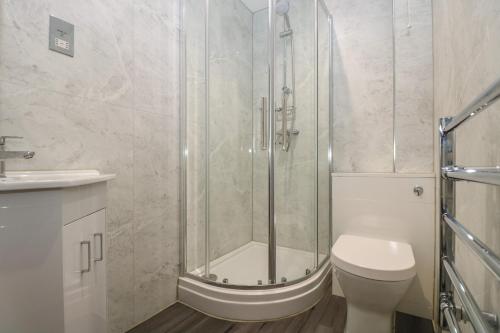 een badkamer met douche, toilet en wastafel bij Compass Point in Falmouth