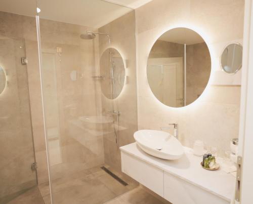a white bathroom with a sink and a shower at Hotel Bernarda in Varaždinske Toplice