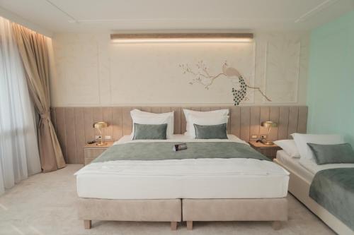 a bedroom with two beds and two lamps in it at Hotel Bernarda in Varaždinske Toplice