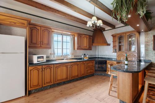 a kitchen with wooden cabinets and a white refrigerator at Casa Rural Tijoco by Paramount Holidays in Adeje