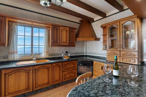 a kitchen with wooden cabinets and a table with wine glasses at Casa Rural Tijoco by Paramount Holidays in Adeje