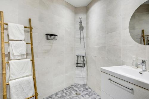 une salle de bain blanche avec lavabo et douche dans l'établissement Sarah 3 - Appt à avec jardin à 200 m de la plage, à Fréhel