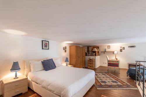 a bedroom with a white bed and a desk at Loft della Rosa by Wonderful Italy in Palermo