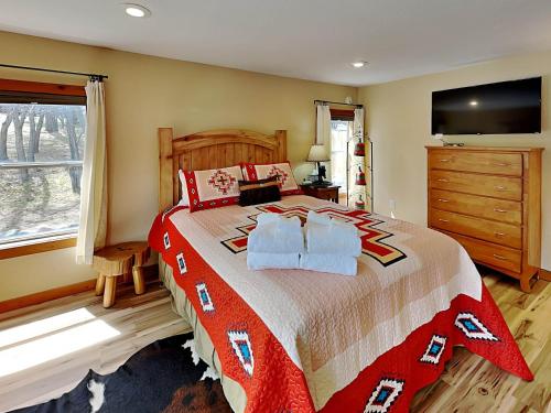 a bedroom with a large bed with a red and white blanket at Double Eagle 2 in Alto