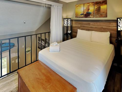 1 dormitorio con cama blanca y balcón en Sandpiper Shores, en Padre Island
