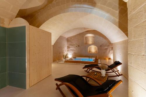 Zimmer mit Badewanne und Stühlen in einem Gebäude in der Unterkunft Endea Suite Rooms & Lounge SPA in Matera