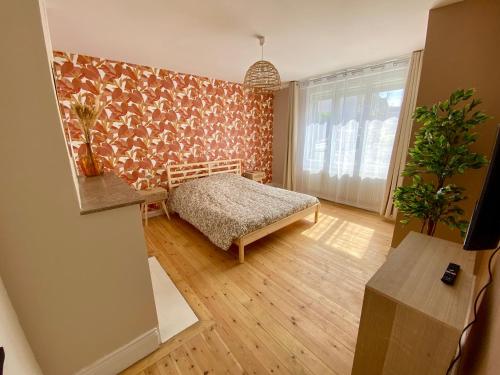 - une chambre avec un lit dans une pièce avec un mur dans l'établissement Les Dunes, à Le Portel