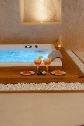 a table with two glasses of food and a bath tub at Endea Suite Rooms & Lounge SPA in Matera