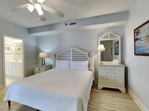 1 dormitorio con cama blanca y espejo en Beach Colony West 8a, en Perdido Key