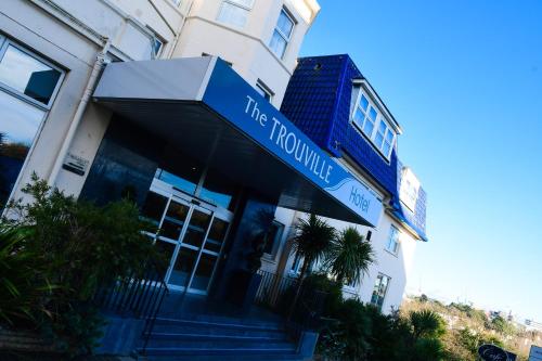 ボーンマスにあるThe Trouville Bournemouthの青い看板が目の前にある建物