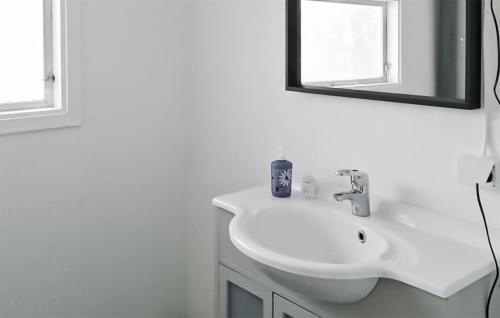 a white bathroom with a sink and a mirror at Nice Home In Bollstabruk With House Sea View in Bollstabruk