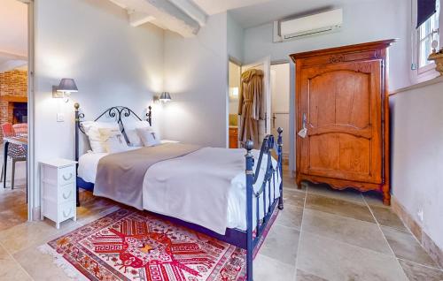 Schlafzimmer mit einem Bett und einem Holzschrank in der Unterkunft Stunning Home In Livarot-pays-dauge With Sauna in Sainte-Marguerite-des-Loges
