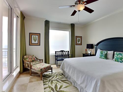 a bedroom with a bed and a fan and a chair at Indigo East 1203 in Perdido Key