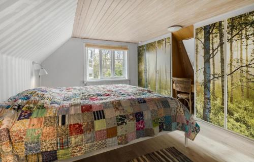 a bedroom with a bed with a quilt on it at 2 Bedroom Pet Friendly Home In Svaneke in Svaneke