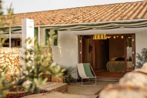 a house with a deck with a chair and a bed at Amagatay Luxury Boutique Hotel - Adults Only in Alaior
