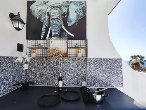 a bathroom with an elephant painting on the wall at Sunshine Escape with ocean view in Adeje