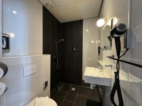 La salle de bains est pourvue de toilettes, d'un lavabo et d'une douche. dans l'établissement Di-Ann City Centre Hotel, à Amsterdam