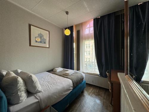 ein kleines Schlafzimmer mit einem Bett und einem Fenster in der Unterkunft Di-Ann City Centre Hotel in Amsterdam