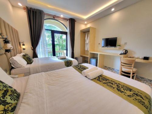 a hotel room with three beds and a television at Hang Meas Boutique in Kampot