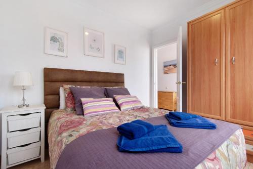 - une chambre avec un lit et des serviettes bleues dans l'établissement Ático Margarita, à Las Palmas de Gran Canaria