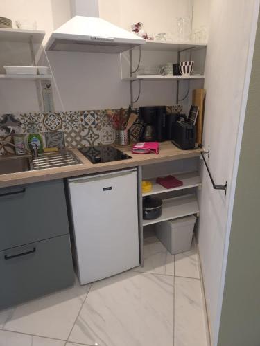 a kitchen with a counter and a white refrigerator at Studio proche lac in Bagnoles de l'Orne