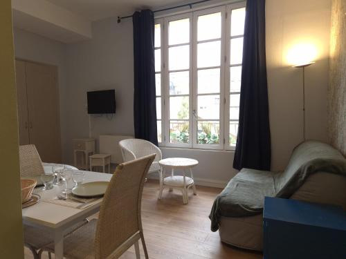 un salon avec une table et une fenêtre dans l'établissement Studio proche lac, à Bagnoles-de-l'Orne