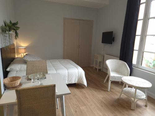 1 dormitorio con 1 cama, mesa y sillas en Studio proche lac en Bagnoles de l'Orne