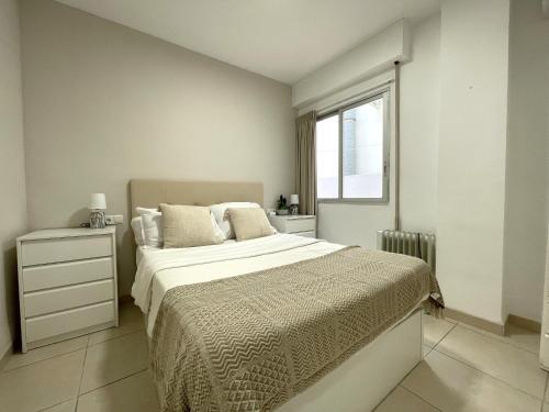 a white bedroom with a bed and a window at Castillo de Moraira in Moraira