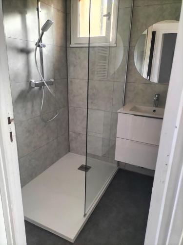 une douche avec une porte vitrée dans une salle de bain dans l'établissement T2 vue mer à Porticcio, proche aéroport Ajaccio, à Porticcio