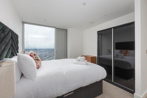 a bedroom with a large white bed with a large window at Greengate in Manchester