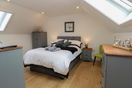 a bedroom with a bed with white sheets and a window at Cuckoo's Rest in Penryn