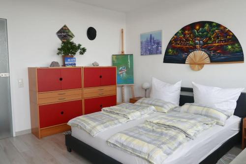 een slaapkamer met een bed en een rode dressoir bij Weser-Panoramablick 10. OG. ColumbusCenter in Bremerhaven