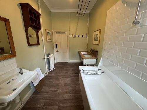 a bathroom with a large tub and a sink and a tub at Ardtornish House Victorian Apartments in Strontian