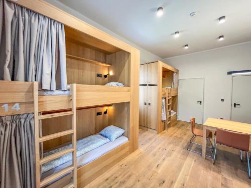 Cette chambre dispose de lits superposés et d'une table. dans l'établissement Ruttner Ház, à Veszprém