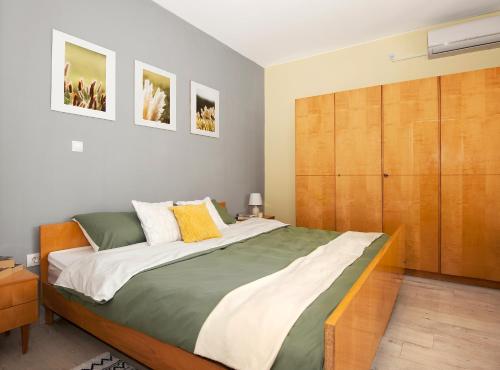 een slaapkamer met een groot bed en een houten kast bij Silvermoon Apartment in Kostrena
