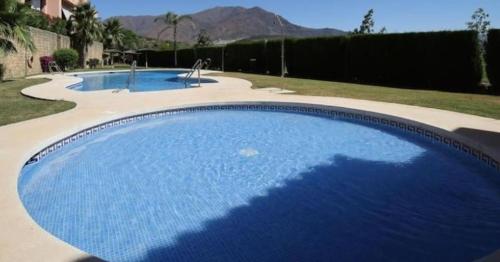 una gran piscina azul en un patio en Noctua Azata Golf Estepona 015, en Estepona
