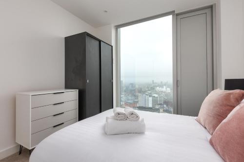 a bedroom with a white bed with a pair of shoes on it at Greengate in Manchester