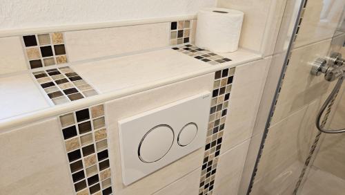 a bathroom with a white cabinet with a roll of toilet paper at Hotel Dorfkrug Büsum - günstige Altbauzimmer Am Oland in Büsum