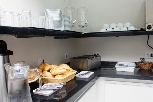 a kitchen with a counter with bread and plates at Hotel New House in Sao Paulo