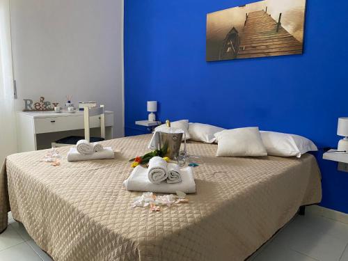 a blue bedroom with a bed with towels on it at Il Giardino Di Capo Vaticano B&B and Apartments in Capo Vaticano