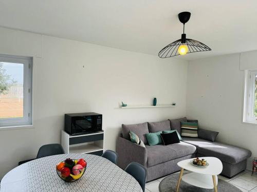 un salon avec un canapé et une table dans l'établissement Appartement confortable, 2 chambres, proche plage, à Carnac