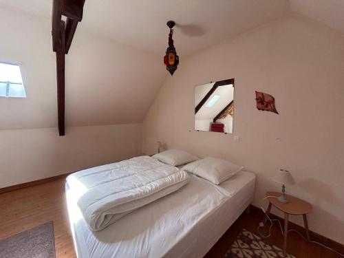 a bedroom with a white bed in a room at Gîte Rosalie, piscine couverte chauffée - Au bord de l'eau Conciergerie in Plouagat