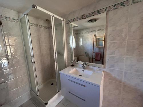 a bathroom with a sink and a shower at Gîte Rosalie, piscine couverte chauffée - Au bord de l'eau Conciergerie in Plouagat