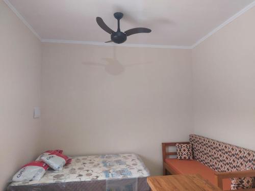 a bedroom with a ceiling fan and a bed at Chalés Praia São Lourenço in Bertioga