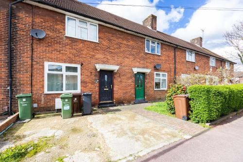 a brick house with two trash cans in front of it at DAGENHAM 3 and 4 BEDROOMS 2BATHS with Parking in Dagenham
