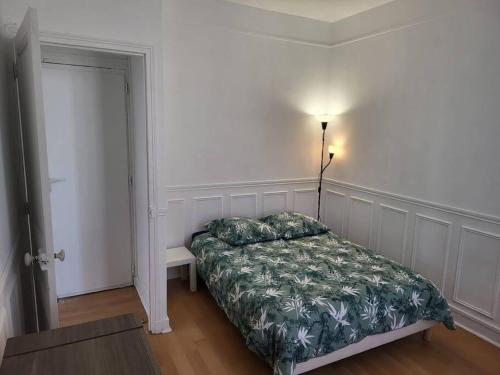 um quarto com uma cama e um candeeiro ao lado de uma porta em TM Appartement chouette em Vitry-sur-Seine