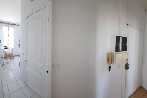 um corredor com paredes brancas e um telefone na parede em TM Appartement chouette em Vitry-sur-Seine