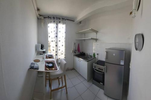 uma pequena cozinha com um frigorífico e um balcão em TM Appartement chouette em Vitry-sur-Seine