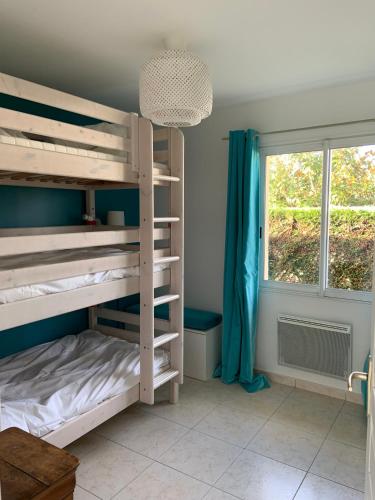 une chambre avec lits superposés et une fenêtre dans l'établissement Maison proche Hossegor, à Tosse